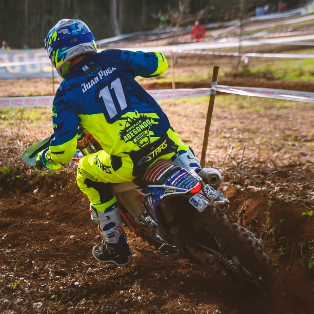 motorista sobre moto de motocros do equipo motoclub abegondo enduro de costas